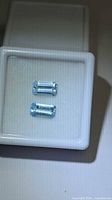 Pair of emerald-cut light blue aquamarines in display case