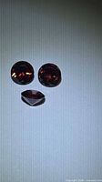 Front view of three garnets showing two round and one marquise cuts