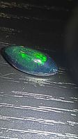 Top view of Ethiopian black opal showing marquise shape and green play of color