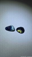Pair of loose bicolored sapphires on neutral background