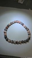 Full view of stretch bracelet showing round pink zebra jasper beads