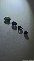 Four faceted sapphires under spotlight