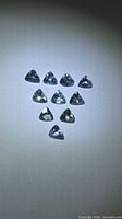 Ten small trillion-cut tanzanites arranged in a triangle formation