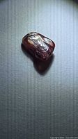 Top view of single pinkish orange-red sapphire crystal