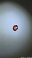 Front view of oval cabochon spinel under direct light