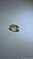 Loose yellow oval scapolite on neutral background