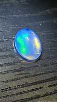 Front view of oval opal cabochon showing blue, green and yellow play-of-color