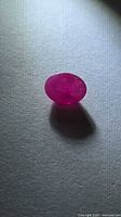 Oval faceted ruby side-lit showing body color and translucency