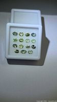 Top view of 15 oval lemon-lime tanzanites in display case