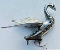 Right-side view of chrome swan ornament showing wing, colored lenses, mounting bolts and wire