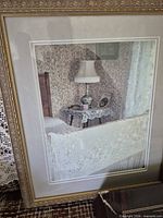 Front of frame showing photograph of embroidered textile on bed