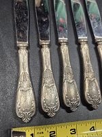 Four ornate EPNS silverplated knife handles close-up