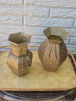 Front view of both embossed brass vases on tray