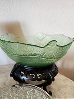 Overall view of green glass bowl on black stand