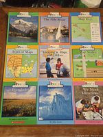 Nine Rookie Read-About Geography and Science books laid out in grid