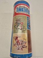 Full view of cardboard cylinder canister with Tinkertoy graphics