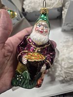 Front view of Leprechaun glass ornament held in hand