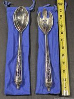 Spoon and fork on blue pouches with tape measure showing length