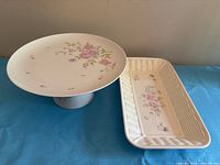 Pedestal cake plate and rectangular platter side by side on table