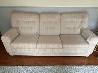 Front view of light beige corduroy three-seat sofa
