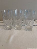 six clear cut crystal highball glasses standing upright