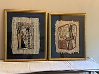 Both framed Egyptian papyrus prints side by side
