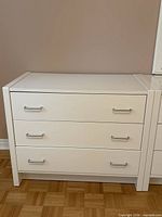 Front view of white 3-drawer dresser with silver handles