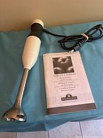 Full view of hand blender and manual on table