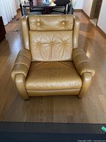 Front view of orange leather tufted armchair