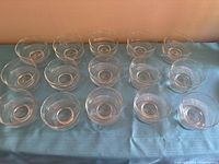 All fifteen clear glass stemmed cups arranged in rows