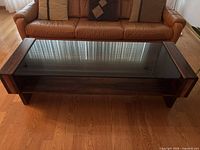 Top view of teak coffee table showing glass surface and shelf