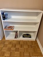 Front view of white bookshelf showing three shelves