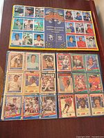 Binder page showing multiple Donruss and Score baseball cards and MLB sticker sheet