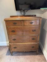 Front view of brown five-drawer dresser
