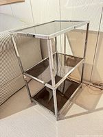 Front angled view showing entire chrome frame and three smoked glass shelves