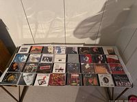 Wide shot showing 24 CD cases laid out on table