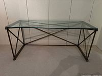 Full front view of glass top metal console table