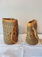 Two woven straw backpacks side by side showing patterns and drawstrings