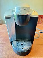 Front view of Keurig B145 coffee maker showing water reservoir and drip tray