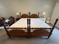 Full view of assembled four-poster king bed showing headboard, footboard, posts, mattress