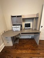 Front view of L-shaped desk showing hutch, pedestal, monitor and printer (not included)