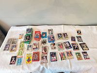 Spread of numerous baseball cards from various 1980s-1990s sets laid out on table