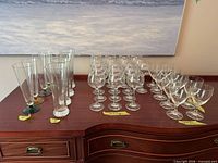 Entire lot showing four colored-base pilsner flutes and eighteen wine glasses