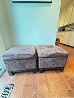 Two brown microfiber ottomans closed, wood legs visible
