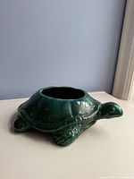Side view of green ceramic turtle planter