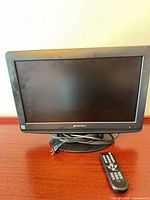 Front view of Sansui 19-inch LCD TV on stand with remote and coiled cables