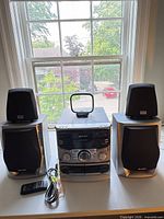 Full set showing main unit, two speakers, remote, antenna, cables