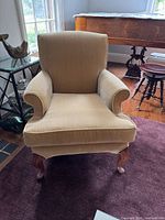 Front view of beige velvet Queen Anne armchair showing seat cushion, rolled arms, cabriole legs
