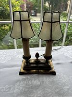 Front view of double-light brass lamp with capiz shades