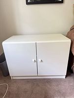 Front view of closed white cabinet with two doors